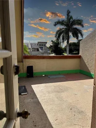 a palm tree sitting in front of a house with a yard
