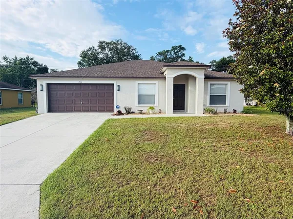 a front view of a house with yard and garage