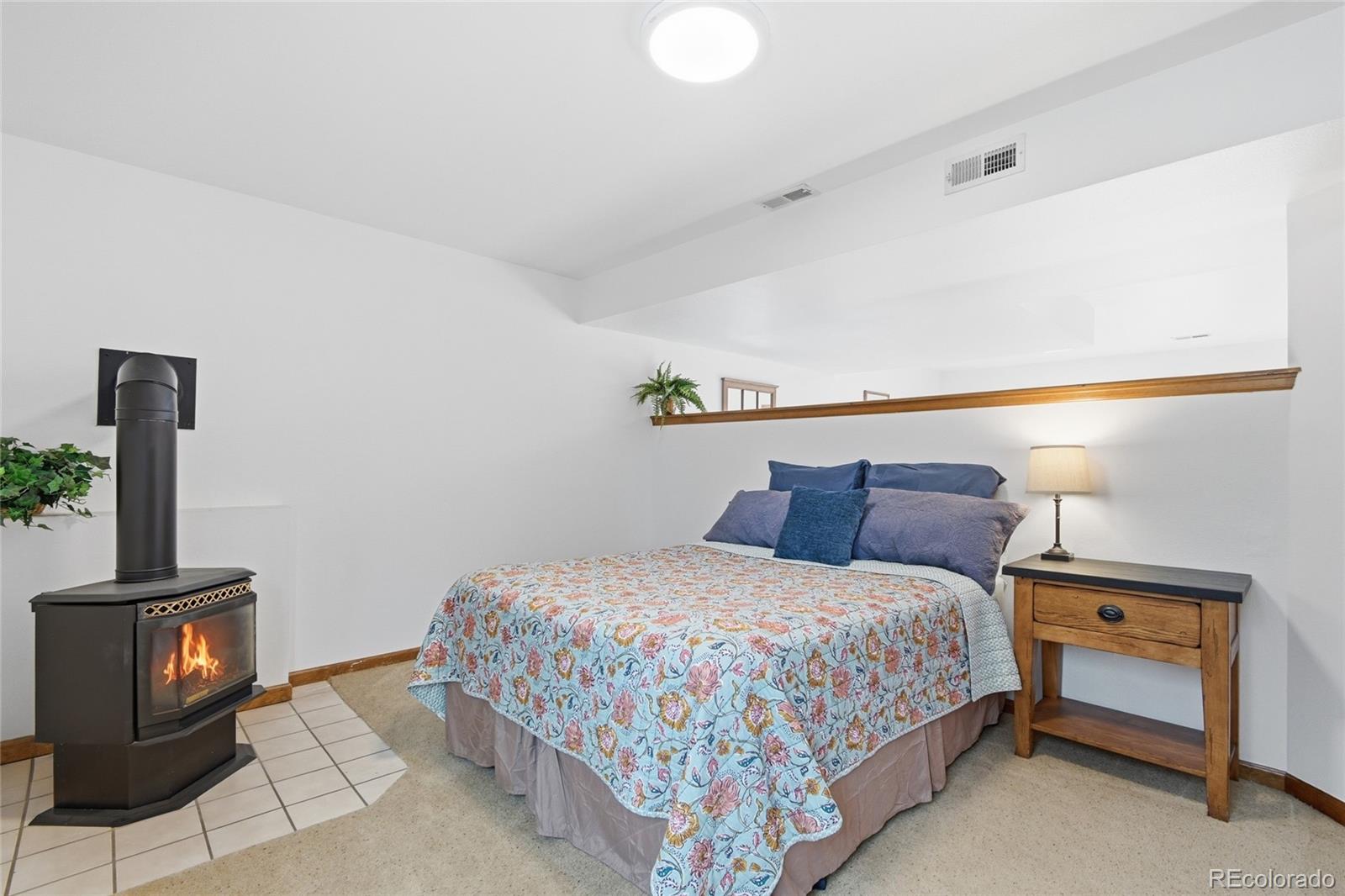 1146 Tapadero Road Bailey, CO 80421 - Photo 18 of 28 a bedroom with a bed and a flat screen tv