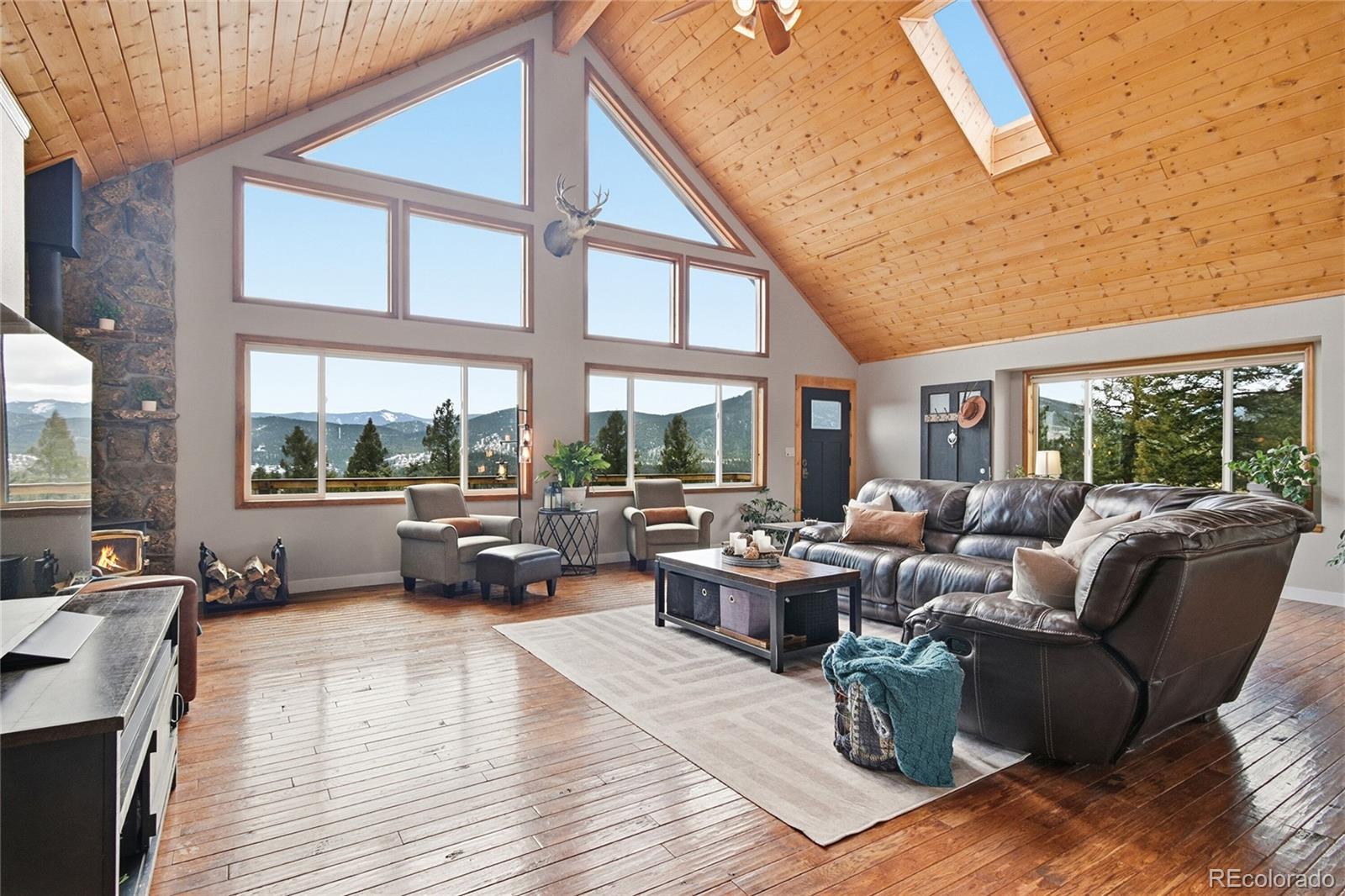 1146 Tapadero Road Bailey, CO 80421 - Photo 2 of 28 a living room with furniture large windows and wooden floor