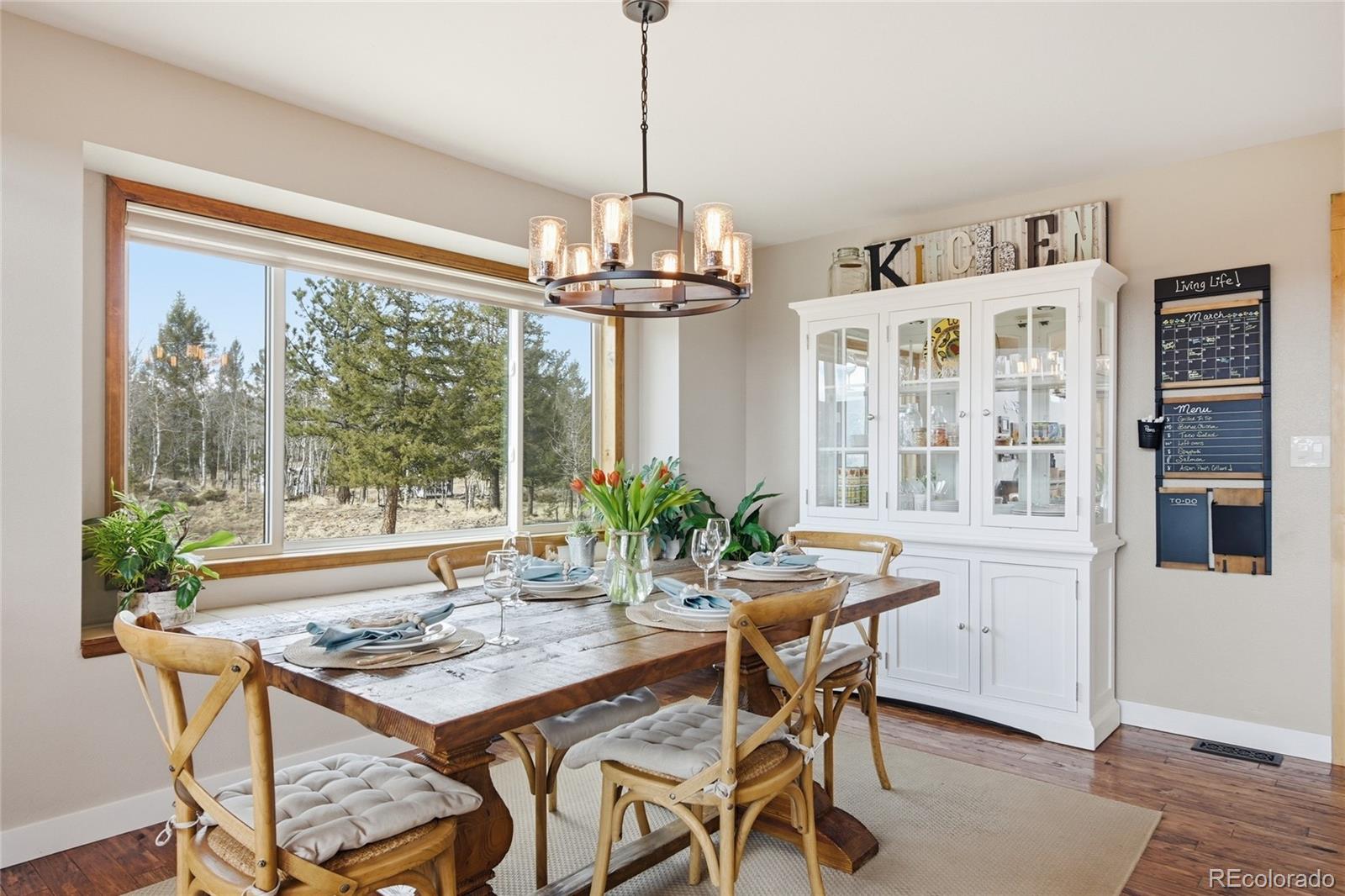 1146 Tapadero Road Bailey, CO 80421 - Photo 9 of 28 a view of a dining room with furniture large windows and wooden floor