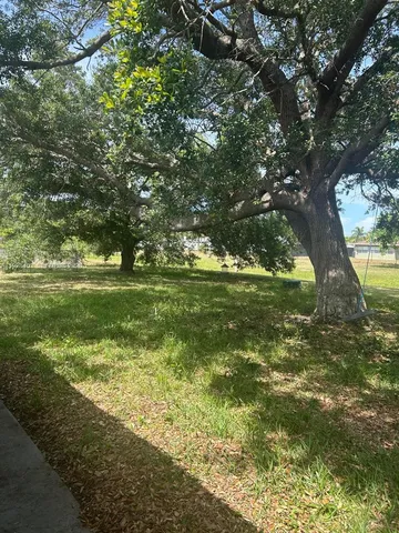 a yard with swimming pool and green space