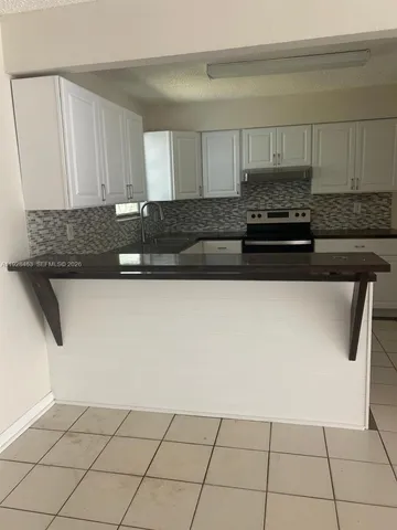 a kitchen with granite countertop a sink and a stove