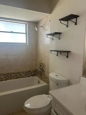 a white toilet and tub sitting next to a bathroom sink
