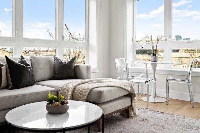 a living room with furniture a chandelier and a dining table
