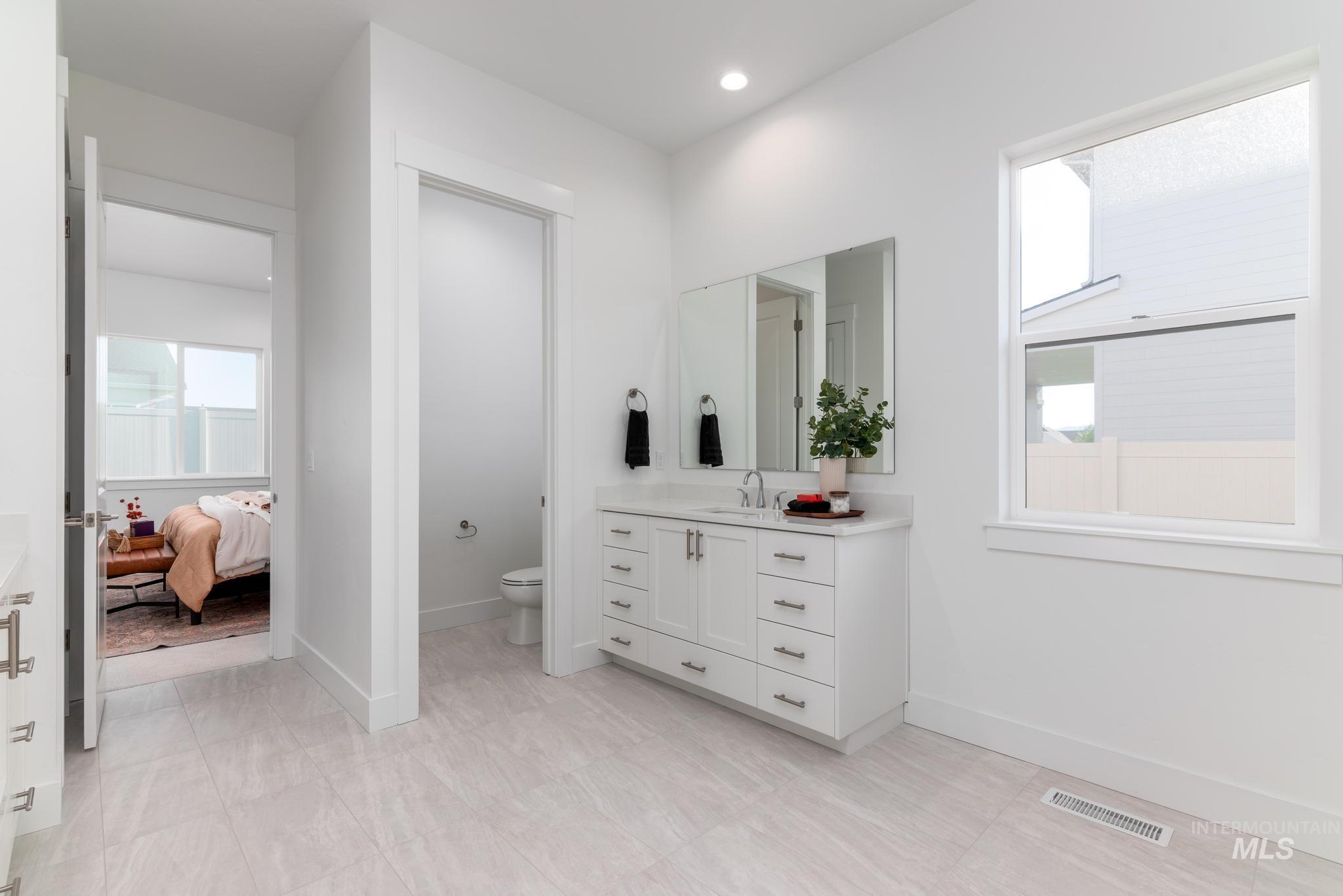 9074 West Moonglade Street Star, ID 83669 - Photo 20 of 40 Bathroom featuring a white vanity with a rectangular sink and brushed nickel faucet, a white countertop, and dual mirrors