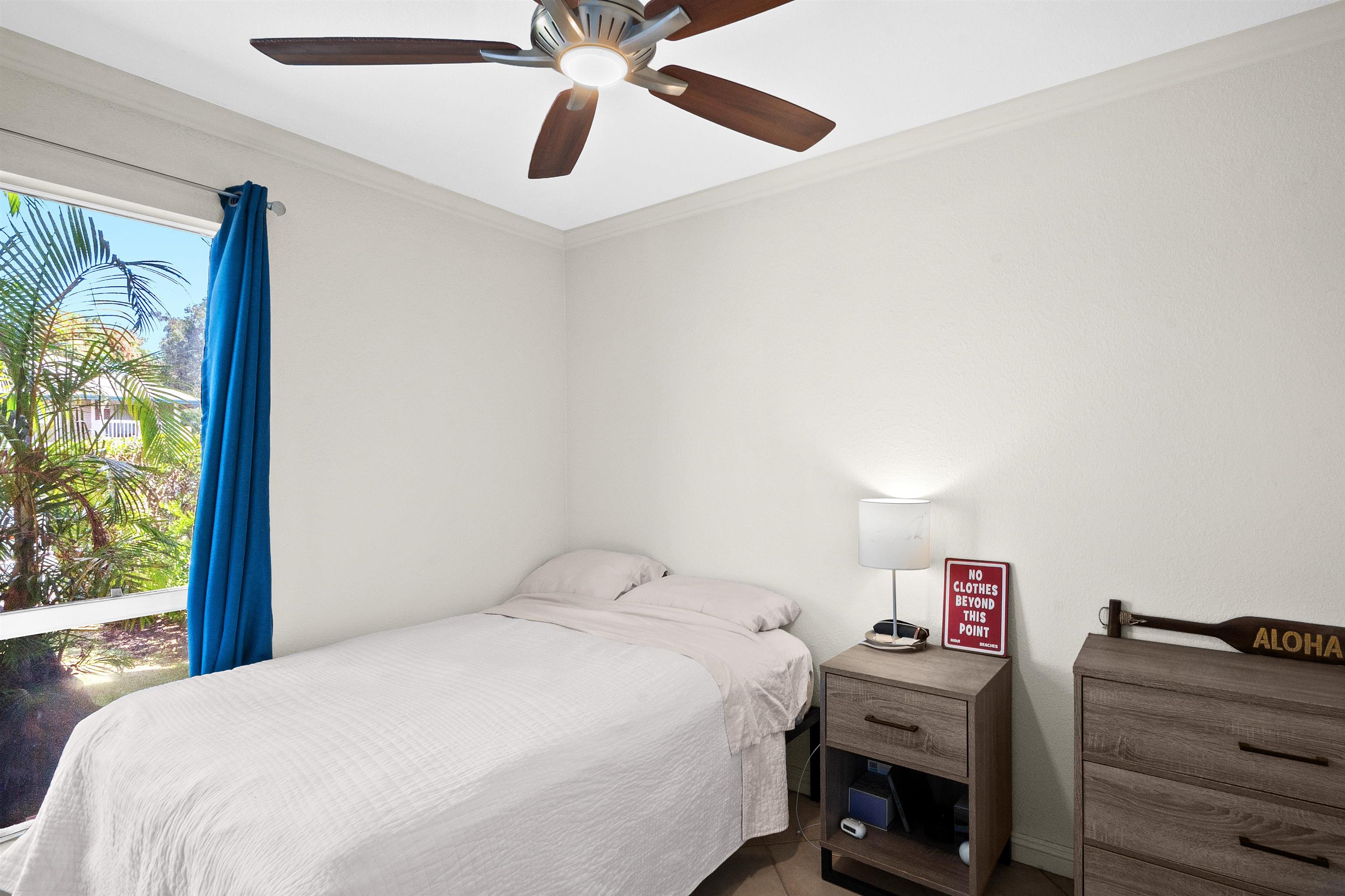 480 Kenolio Road, Unit 15103 Kihei, HI 96753 - Photo 15 of 36 a bedroom with a bed and a chandelier