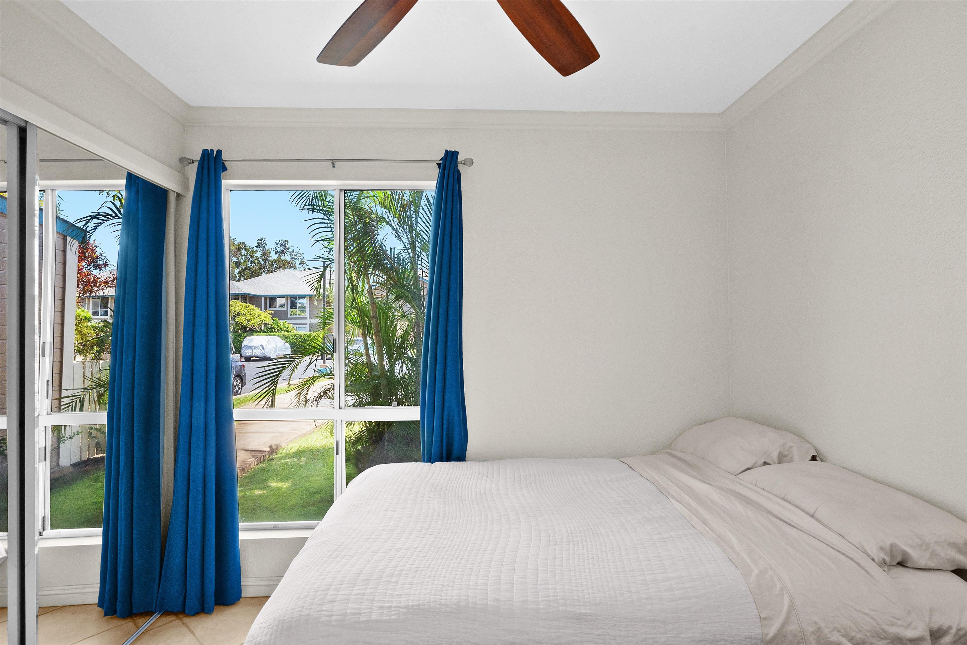 480 Kenolio Road, Unit 15103 Kihei, HI 96753 - Photo 16 of 36 a bedroom with a bed and a large window