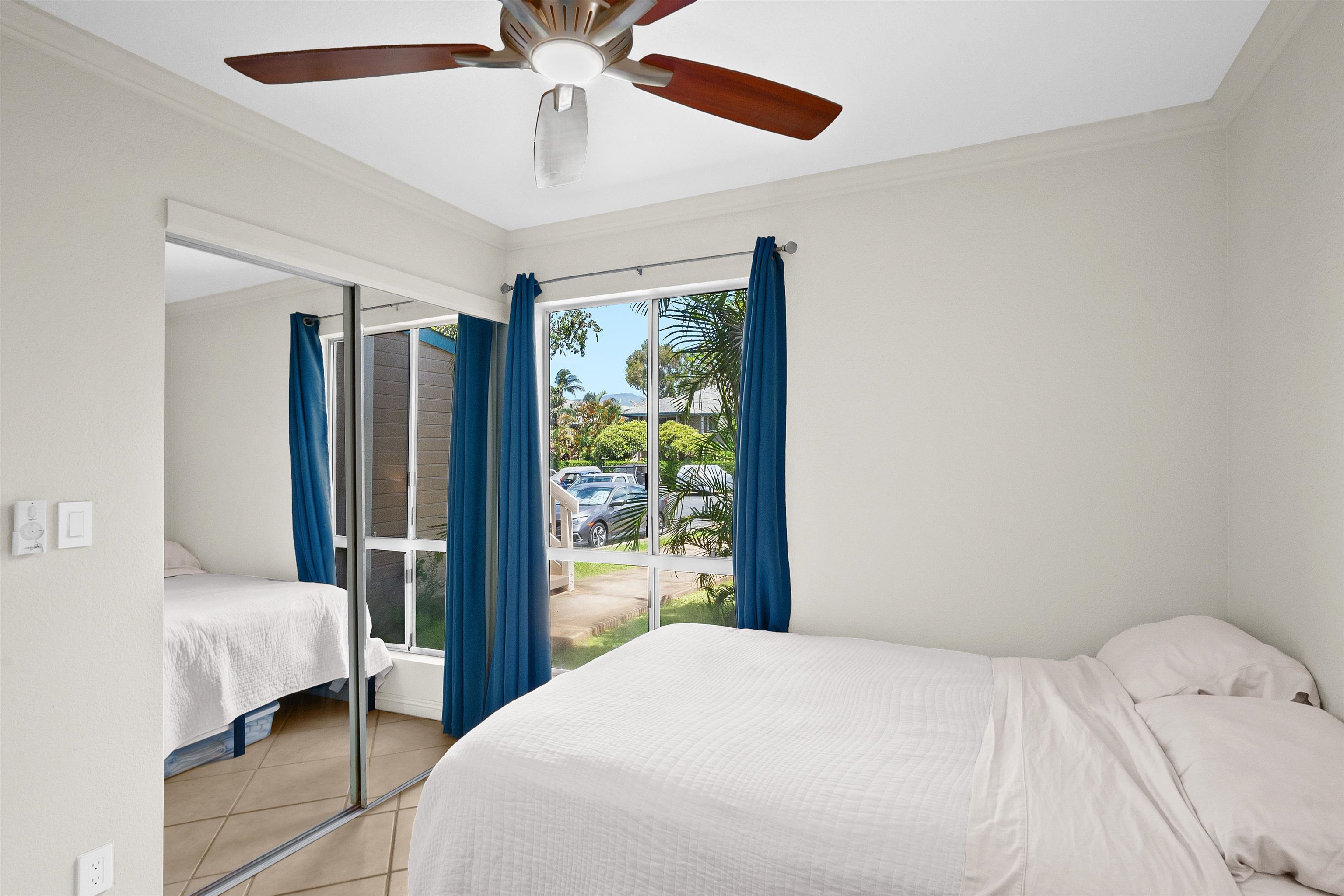 480 Kenolio Road, Unit 15103 Kihei, HI 96753 - Photo 17 of 36 a bedroom with a large bed and a large window
