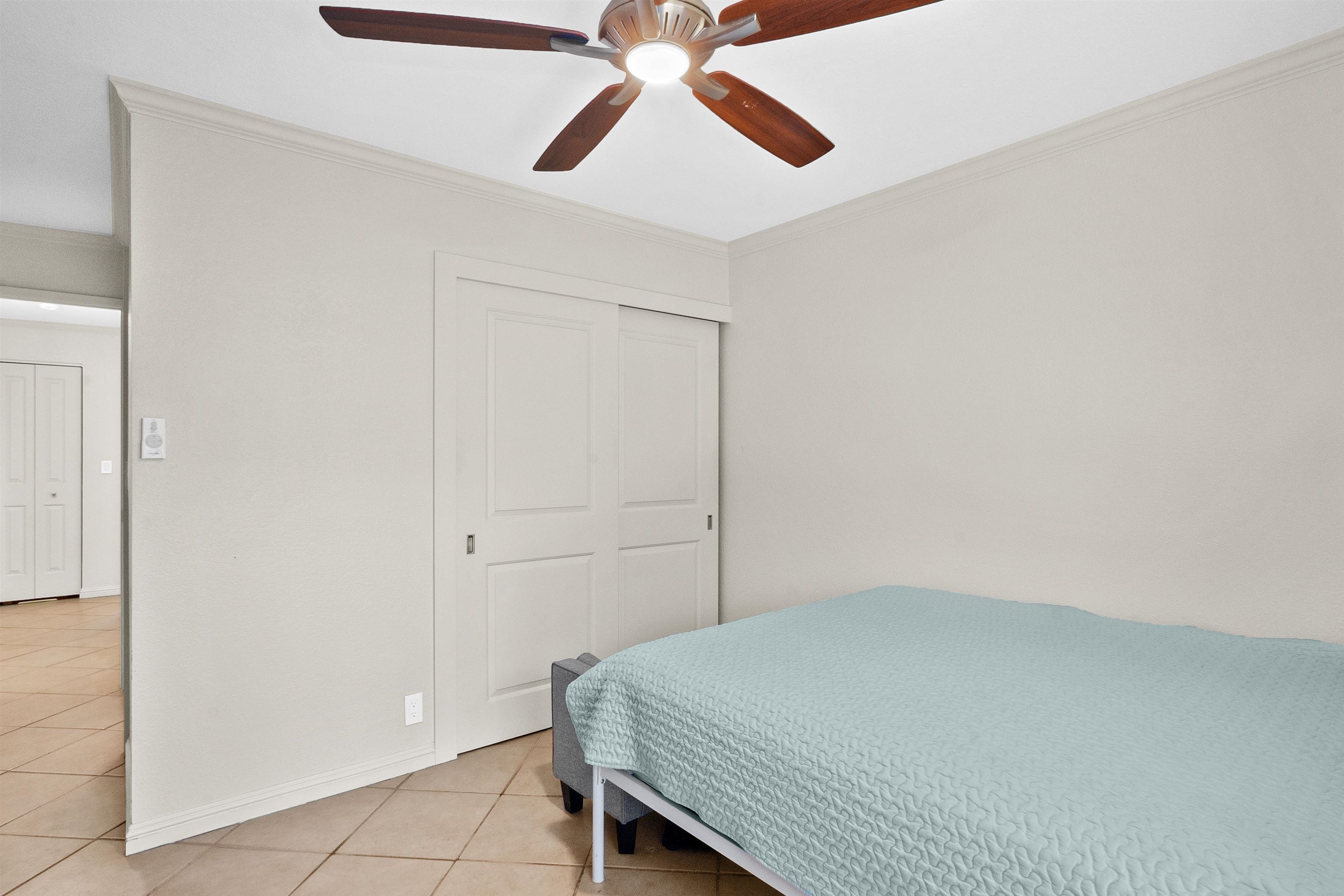 480 Kenolio Road, Unit 15103 Kihei, HI 96753 - Photo 20 of 36 a bedroom with a bed and a chandelier fan