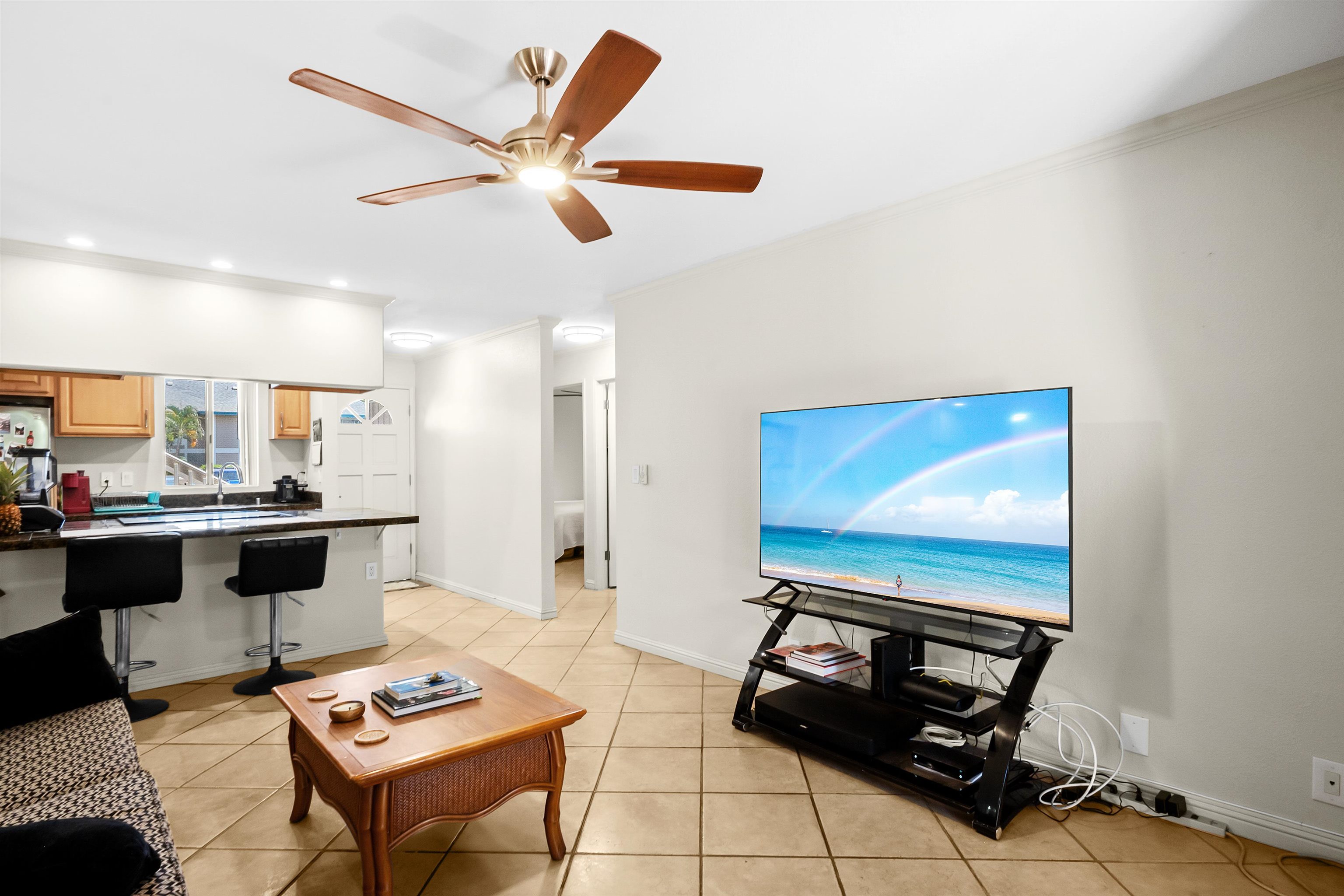 480 Kenolio Road, Unit 15103 Kihei, HI 96753 - Photo 6 of 36 a living room with furniture a rug and a wall painting