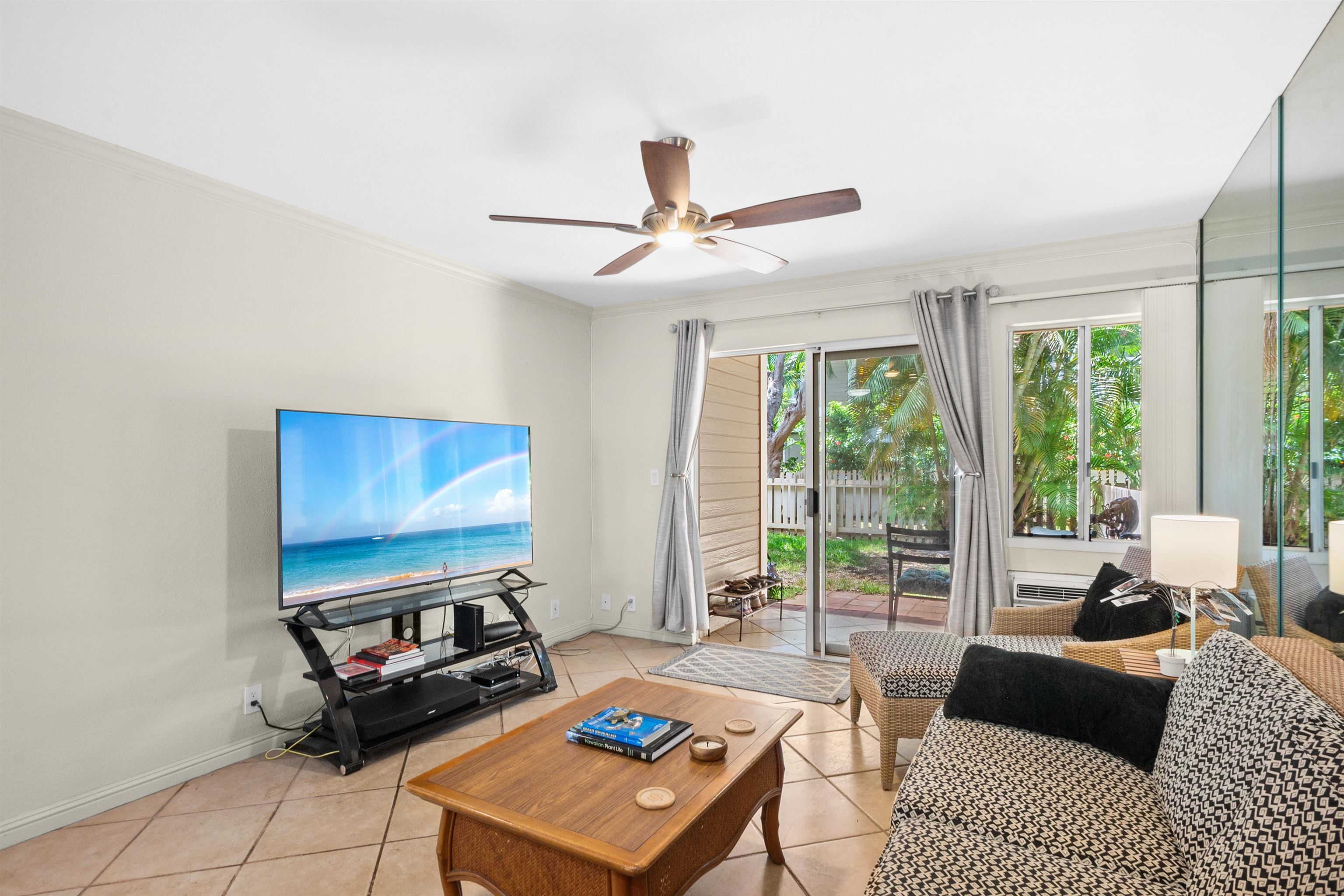 480 Kenolio Road, Unit 15103 Kihei, HI 96753 - Photo 8 of 36 a living room with furniture a flat screen tv and a large window