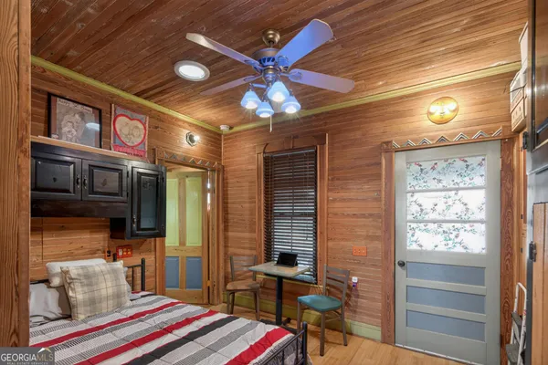 a view of living room kitchen with stainless steel appliances wooden floor and chandelier