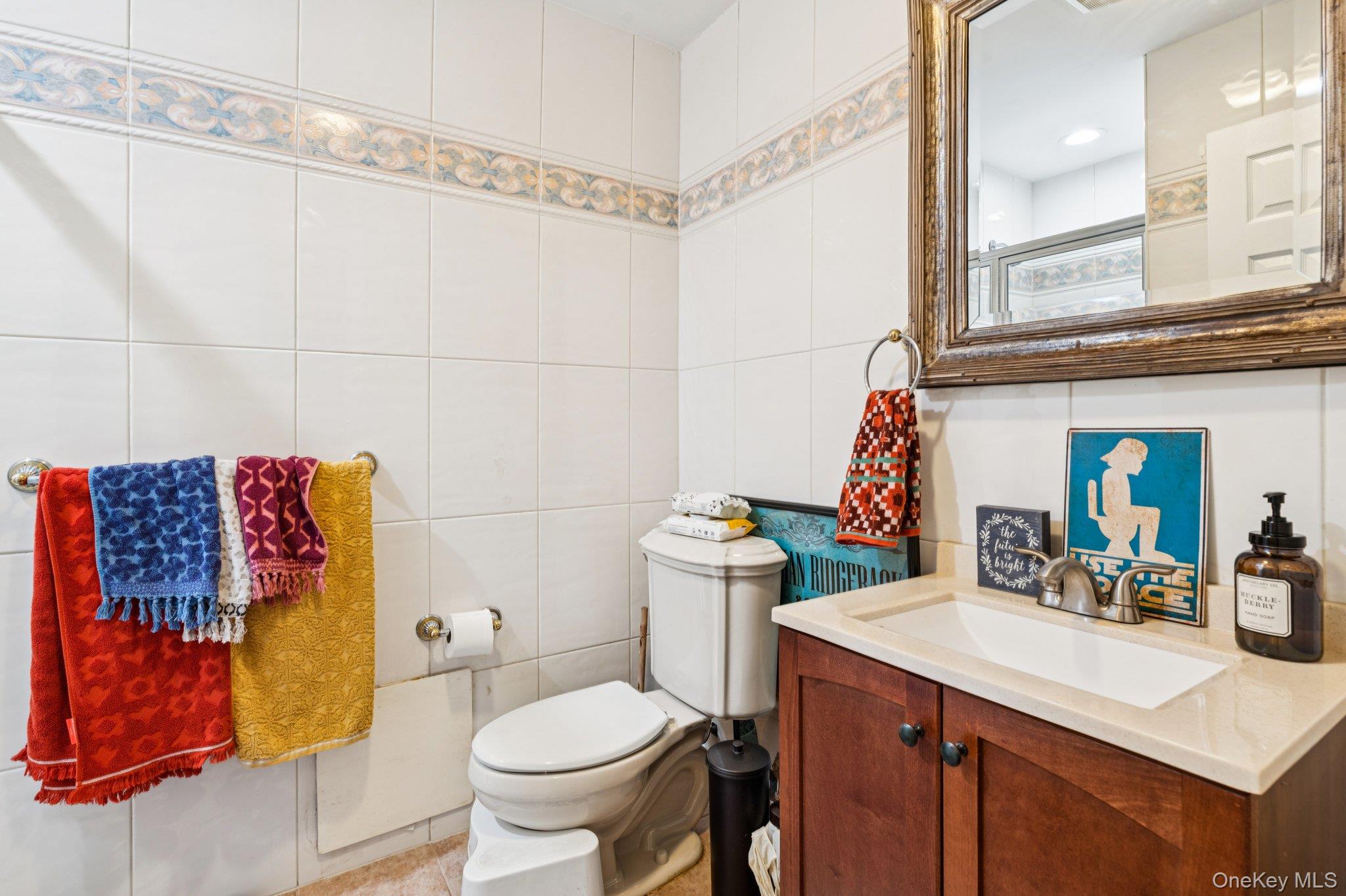 318 East Olive Street, Unit UPPR Long Beach, NY 11561 - Photo 5 of 12 a bathroom with a sink mirror vanity and toilet