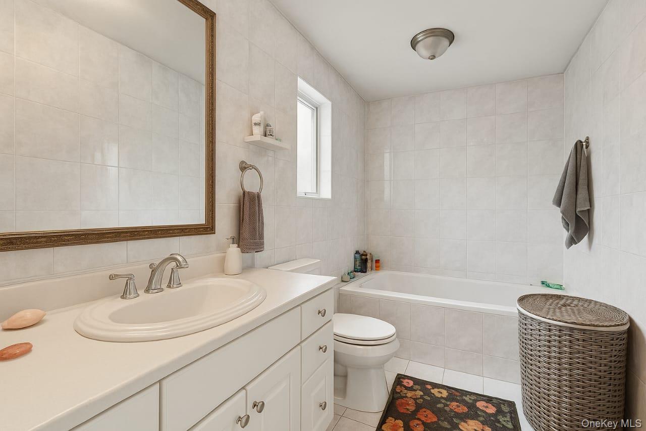 318 East Olive Street, Unit UPPR Long Beach, NY 11561 - Photo 7 of 12 a bathroom with a sink a toilet and a bathtub