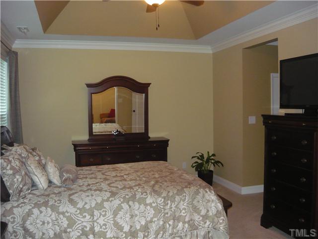 1528 Sedwick Road Durham, NC 27713 - Photo 9 of 18 a bedroom with a bed and a flat tv screen on dresser