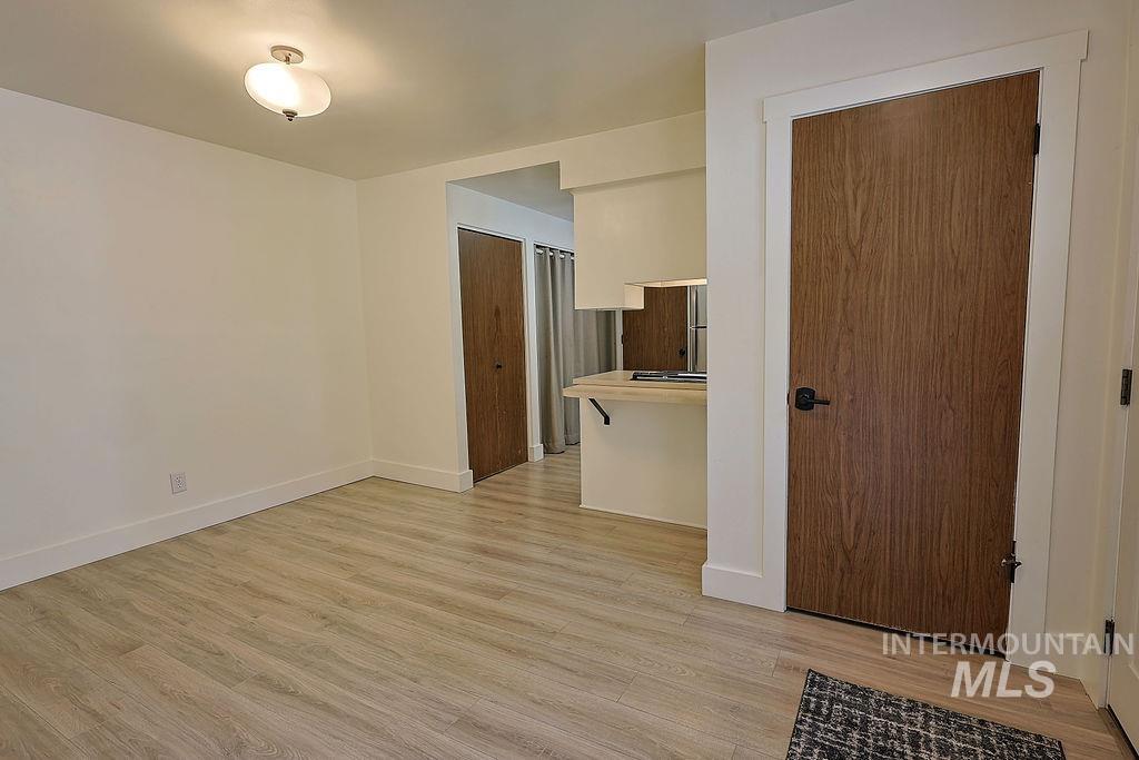 640 Morrison Street Twin Falls, ID 83301 - Photo 6 of 30 Spacious room featuring wood-finish flooring, white baseboards, and a contemporary ceiling light fixture