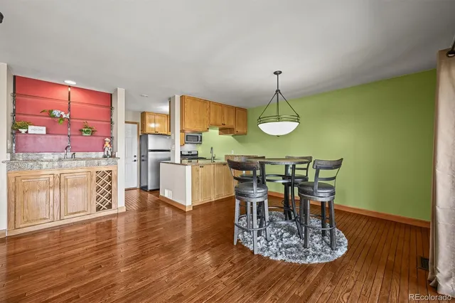 a dining room with wooden floor a chandelier a wooden table and chairs