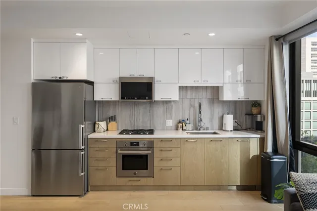 a kitchen with stainless steel appliances granite countertop a refrigerator stove a sink and a microwave