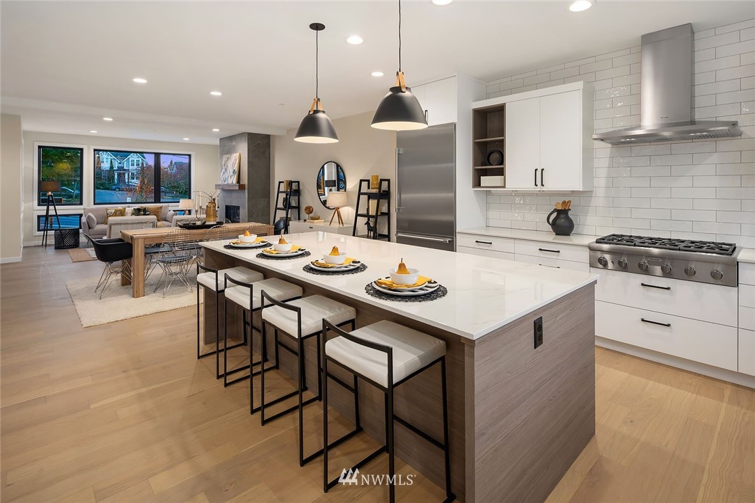 330 3rd Avenue South, Unit B Kirkland, WA 98033 - Photo 11 of 36 a open kitchen with stainless steel appliances kitchen island a table chairs and a refrigerator