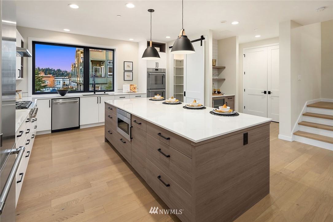 330 3rd Avenue South, Unit B Kirkland, WA 98033 - Photo 12 of 36 a large white kitchen with a large counter top sink and stainless steel appliances