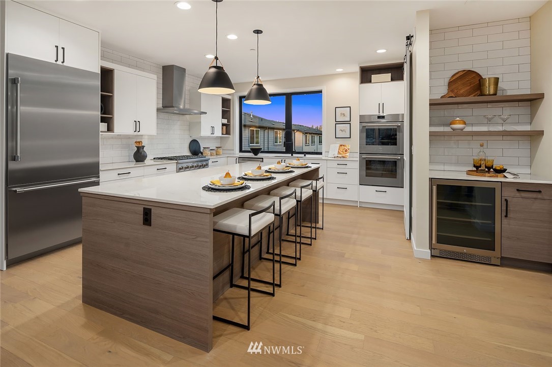 330 3rd Avenue South, Unit B Kirkland, WA 98033 - Photo 9 of 36 a kitchen with stainless steel appliances kitchen island granite countertop a stove and a refrigerator