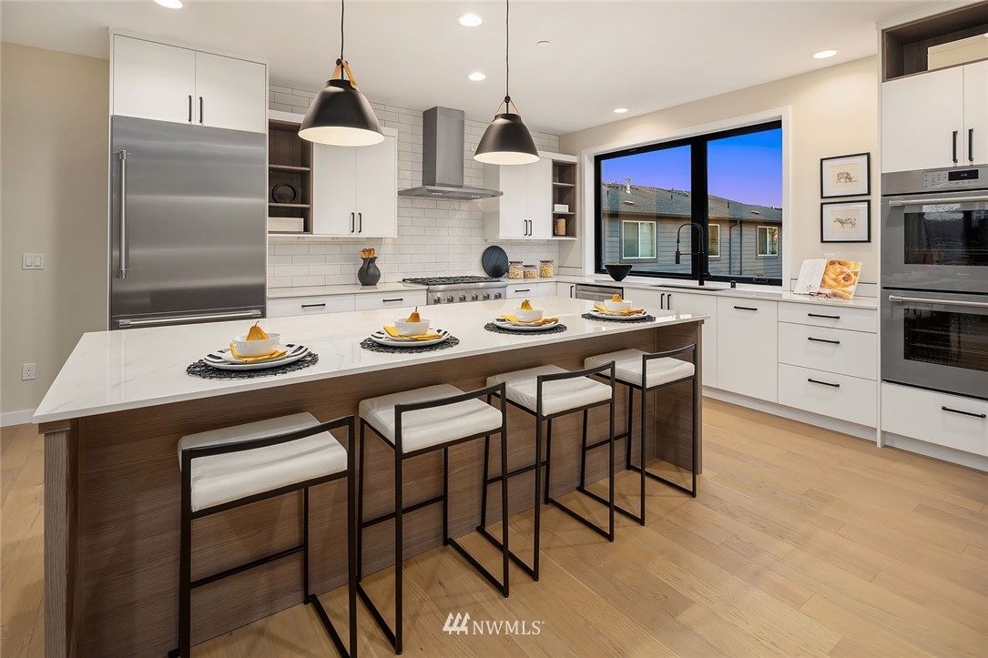 330 3rd Avenue South, Unit B Kirkland, WA 98033 - Photo 10 of 36 a kitchen with stainless steel appliances kitchen island granite countertop a sink a stove a refrigerator cabinets and chairs