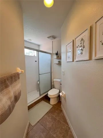 a bathroom with a toilet and a shower