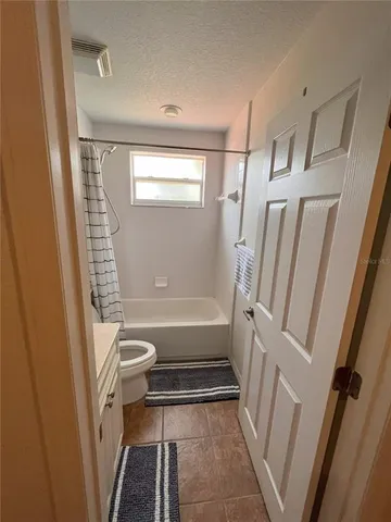 a bathroom with a tub shower and toilet