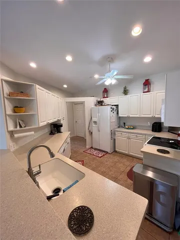 a kitchen that has a lot of cabinets a sink and a stove in it