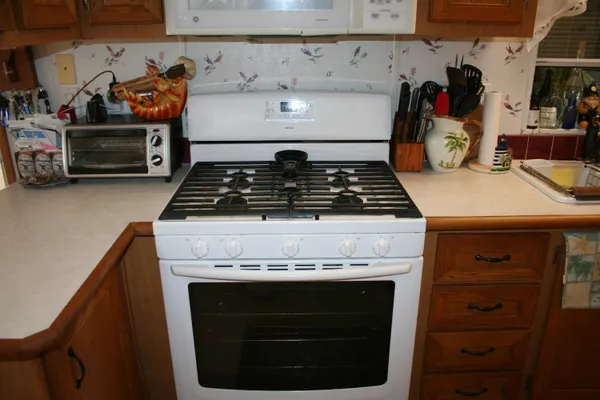 a kitchen with wooden cabinets and a stove top oven