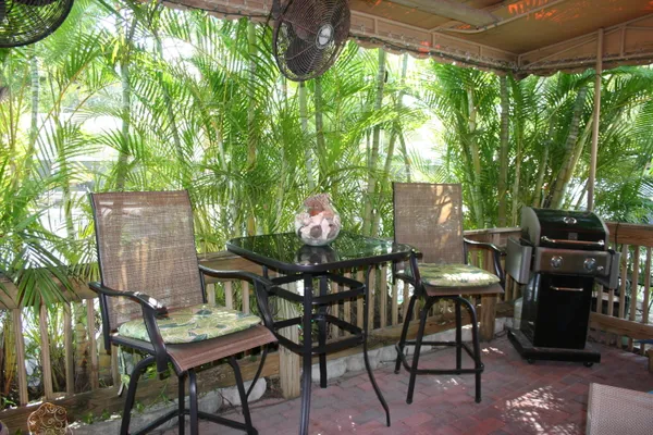 a table and chairs with the view of tree in front of it