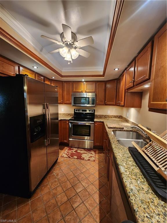 925 Palm View Drive, Unit F120 Naples, FL 34110 - Photo 11 of 25 a kitchen with kitchen island granite countertop a stove top oven a sink and cabinets