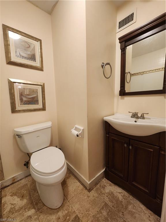 925 Palm View Drive, Unit F120 Naples, FL 34110 - Photo 22 of 25 a bathroom with a toilet sink and mirror