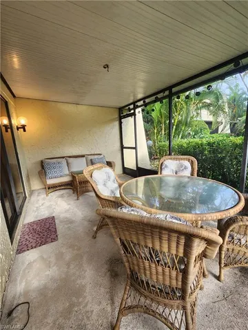 a dining room with furniture and a floor to ceiling window