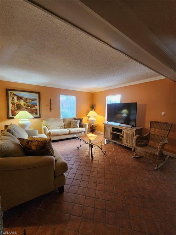 925 Palm View Drive, Unit F120 Naples, FL 34110 - Photo 6 of 25 a living room with furniture and a flat screen tv