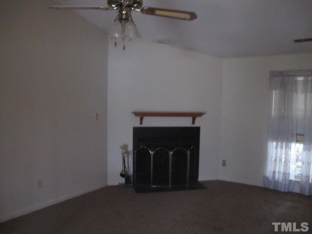 1006 Buckhorn Road Garner, NC 27529 - Photo 6 of 9 a room with a fireplace and a chandelier