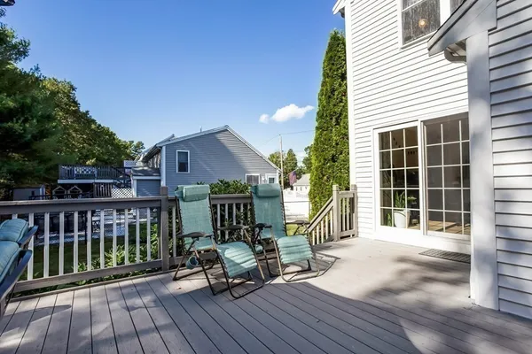 a view of a deck with wooden floor and fence with a bench