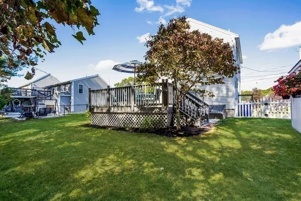a view of a house next to a big yard and large trees
