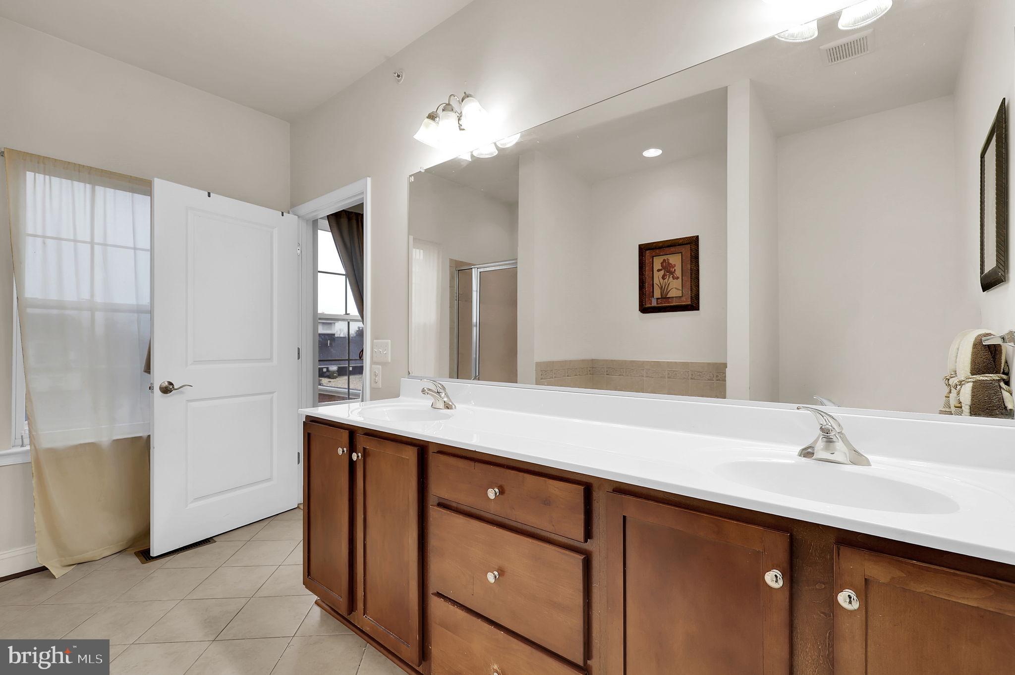 5846 Donovan Lane Ellicott City, MD 21043 - Photo 20 of 31 a bathroom with a double vanity sink mirror and bathtub