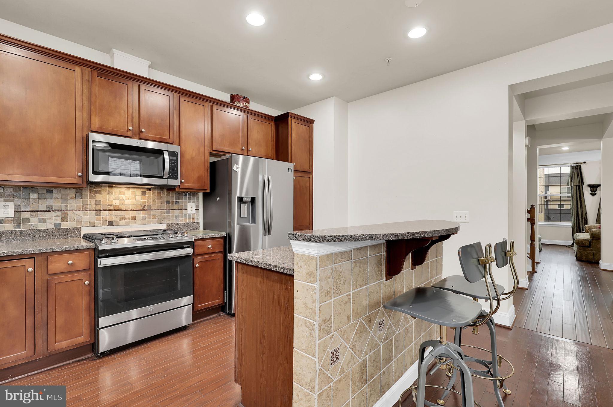 5846 Donovan Lane Ellicott City, MD 21043 - Photo 6 of 31 a kitchen with kitchen island stainless steel appliances a stove microwave and refrigerator