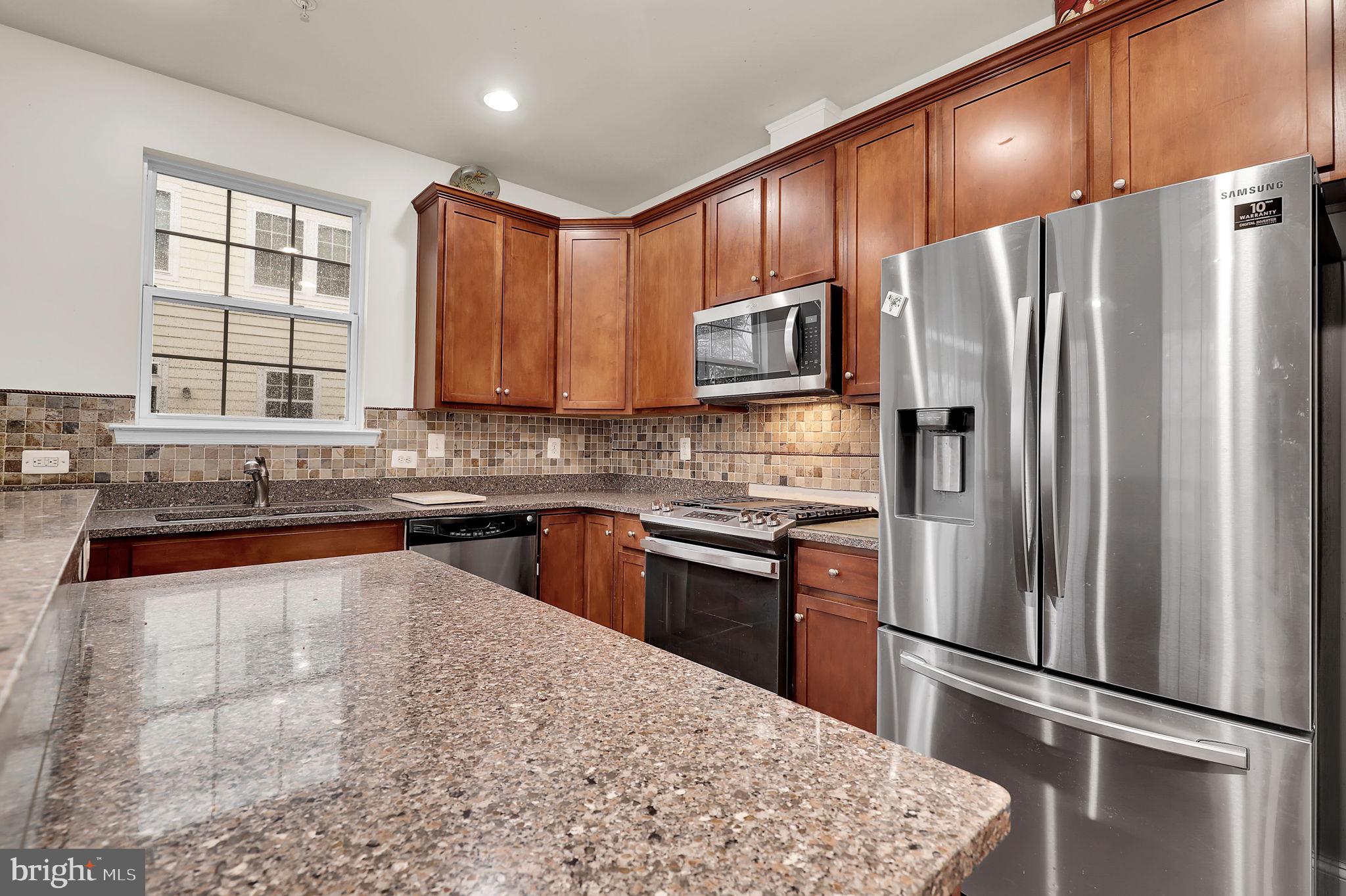 5846 Donovan Lane Ellicott City, MD 21043 - Photo 7 of 31 a kitchen with stainless steel appliances wooden cabinets a refrigerator and a sink