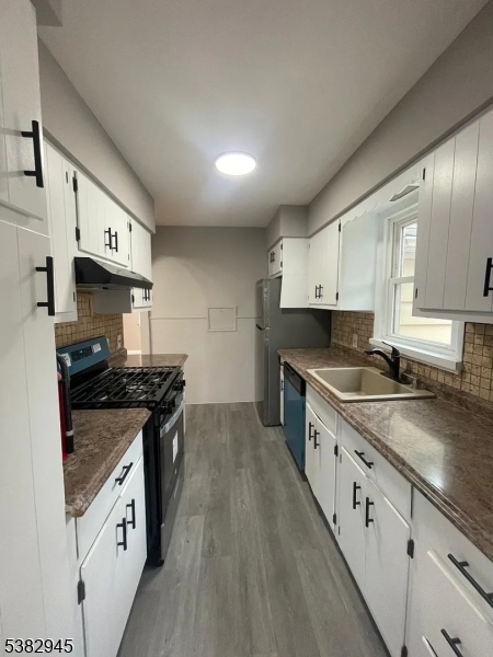 1292 Crescent Avenue Roselle, NJ 07203 - Photo 20 of 35 a kitchen with stainless steel appliances granite countertop a stove a sink and a refrigerator