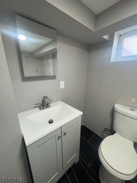 1292 Crescent Avenue Roselle, NJ 07203 - Photo 26 of 35 a bathroom with a toilet sink and mirror