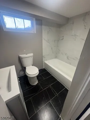 a bathroom with a toilet a sink and a window