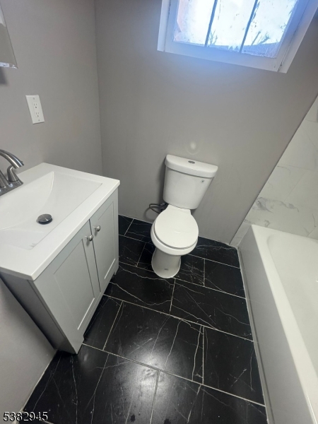 1292 Crescent Avenue Roselle, NJ 07203 - Photo 29 of 35 a bathroom with a toilet a sink and a window