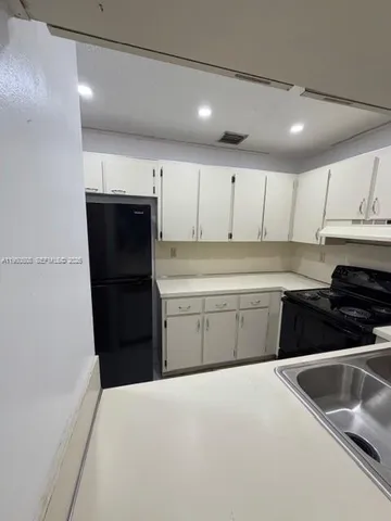 a kitchen with a refrigerator sink and cabinets