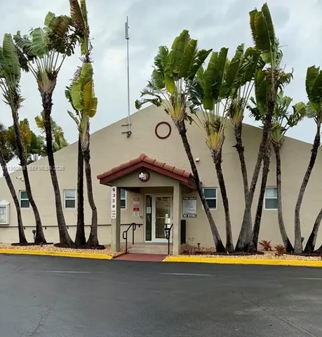 a view of swimming pool with lawn chairs and plants