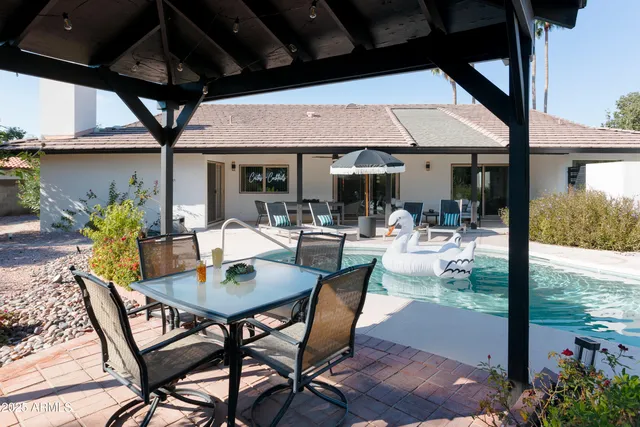 a view of a patio with table and chairs under an umbrella