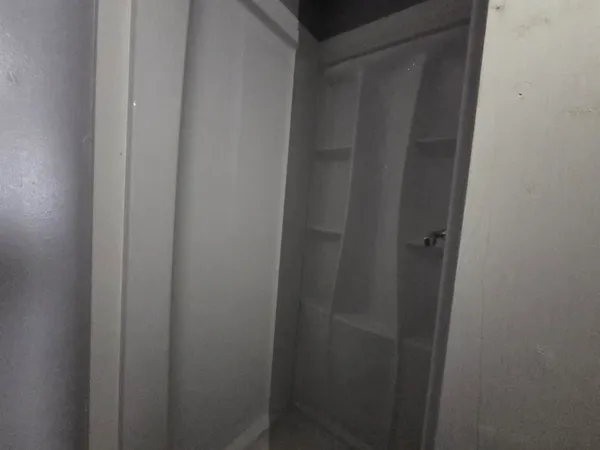 an empty room with windows and closet